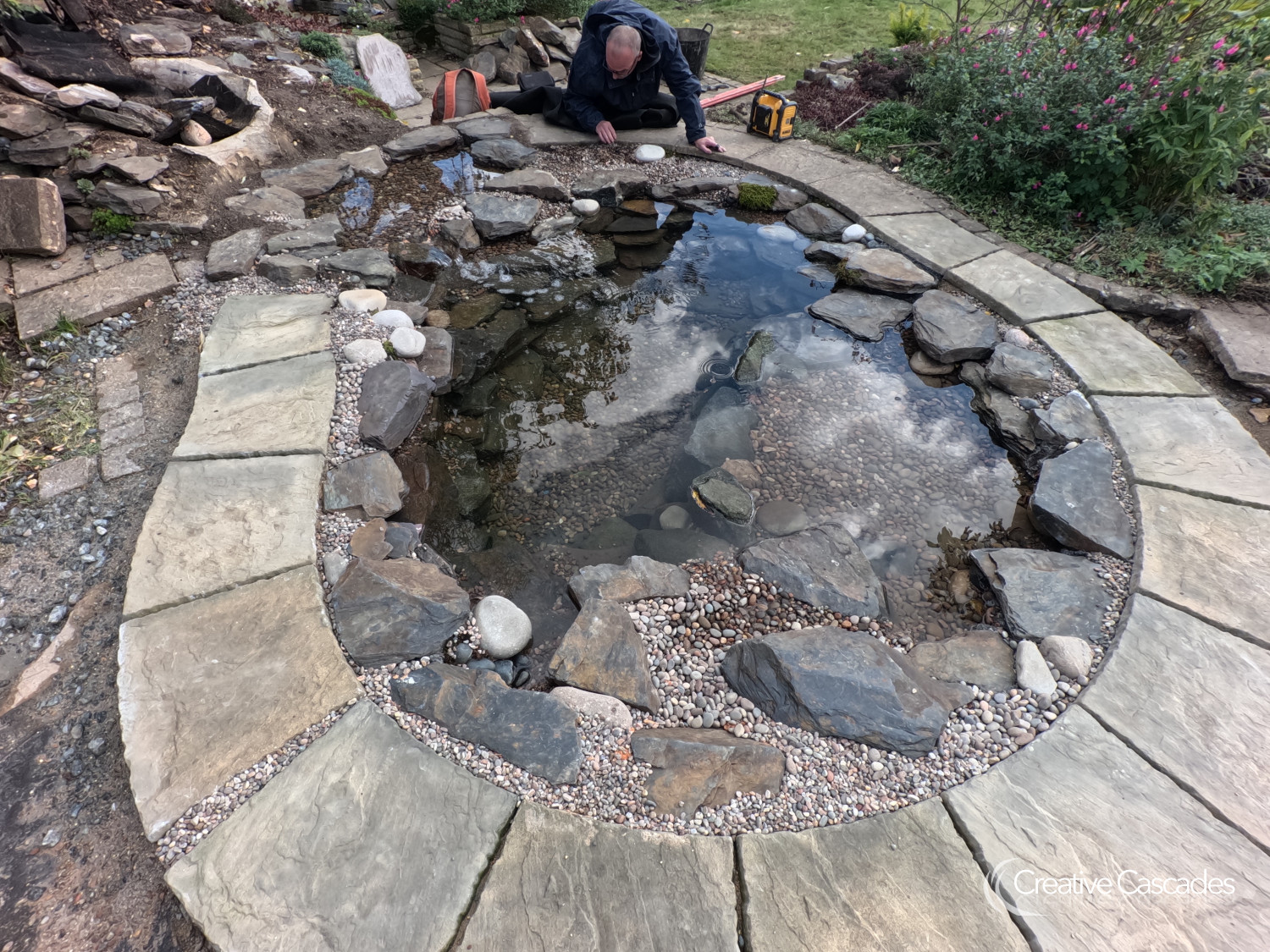 A more formal style ecosystem pond, built in 2024. We used clients existing spare paving slabs.  - Landscaping and Water Features -  Creative Cascades